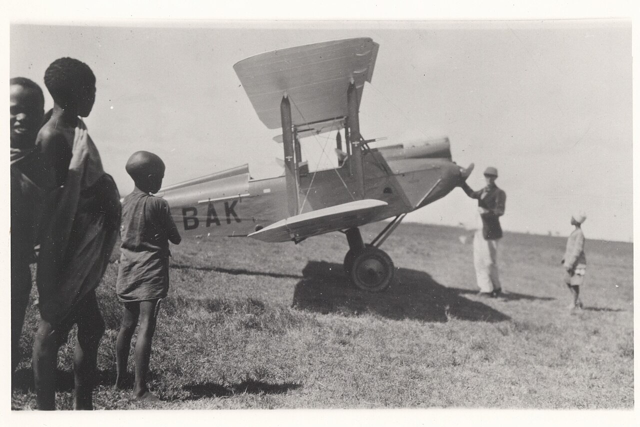 Denys Finch-Hatton showing his Gipsy Moth plane to some of Kenyan children.